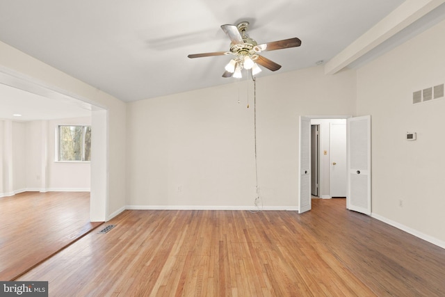 empty room with light wood-style flooring, visible vents, and baseboards