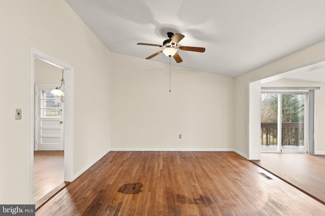 unfurnished room with ceiling fan, wood finished floors, visible vents, and baseboards