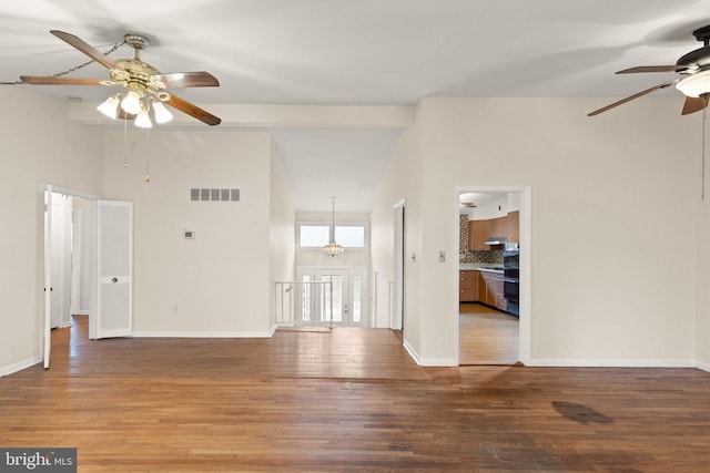 unfurnished living room featuring light wood-style floors, visible vents, high vaulted ceiling, and baseboards