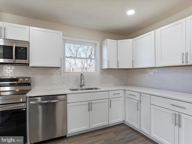 kitchen featuring stainless steel appliances, a sink, light countertops, and white cabinets