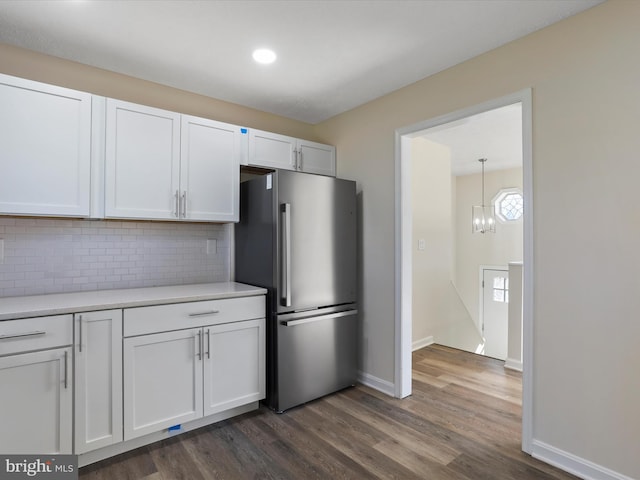 kitchen with freestanding refrigerator, white cabinets, light countertops, and dark wood finished floors