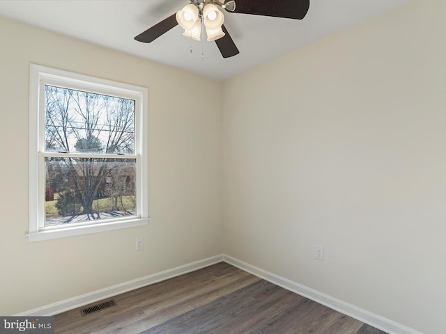 empty room featuring a ceiling fan, baseboards, visible vents, and wood finished floors