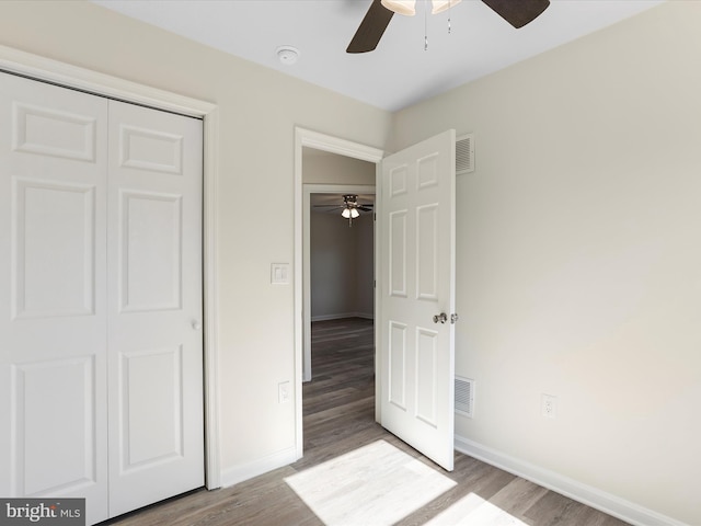 unfurnished bedroom with visible vents, baseboards, and wood finished floors