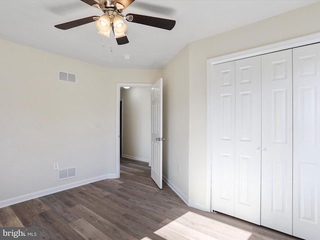 unfurnished bedroom with baseboards, a closet, visible vents, and wood finished floors