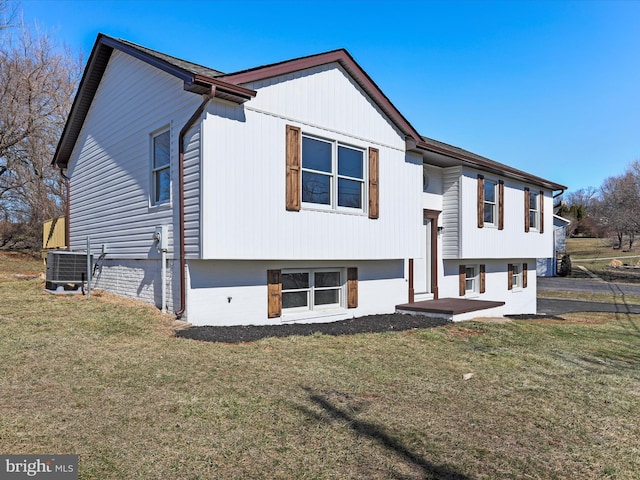 split foyer home with central AC unit and a front yard