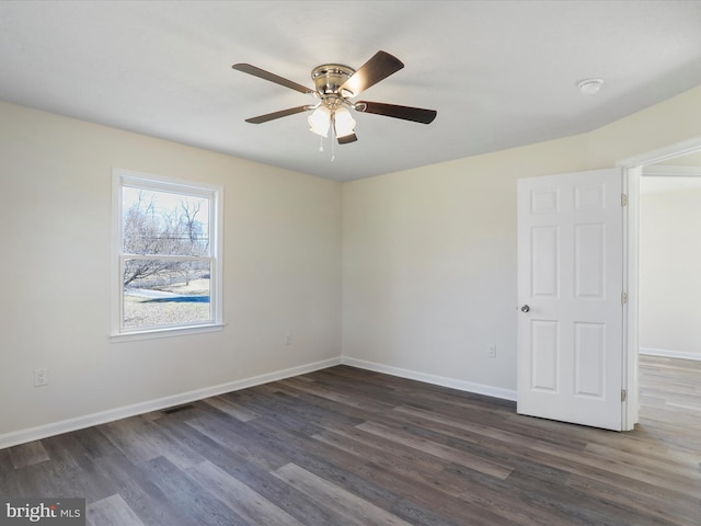 empty room with ceiling fan, visible vents, baseboards, and dark wood-style flooring