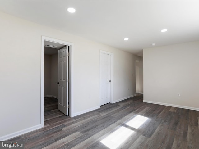 unfurnished room featuring recessed lighting, wood finished floors, visible vents, and baseboards