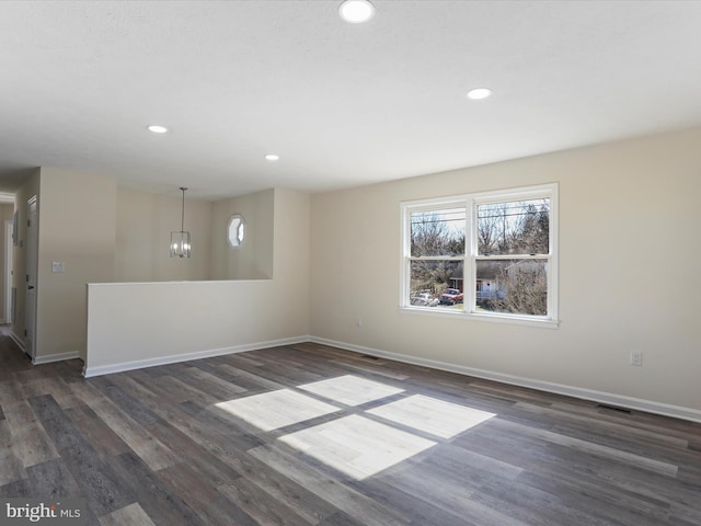 unfurnished room featuring baseboards and dark wood-style flooring