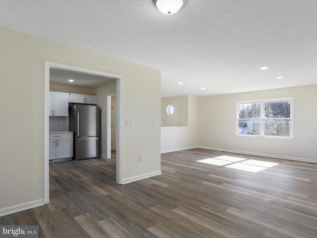 empty room with recessed lighting, dark wood finished floors, and baseboards