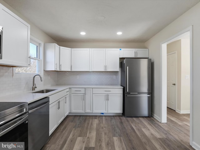 kitchen featuring stainless steel appliances, a sink, light countertops, and white cabinets