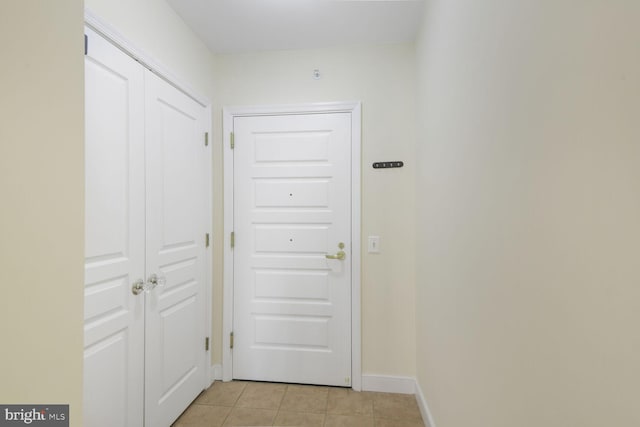 entryway with light tile patterned floors and baseboards