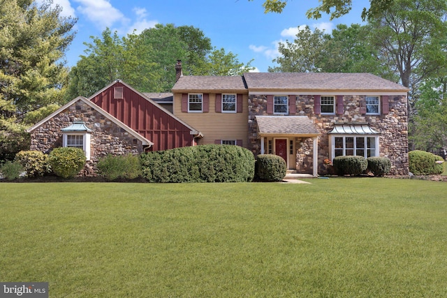 view of front of property with stone siding, board and batten siding, a chimney, and a front yard