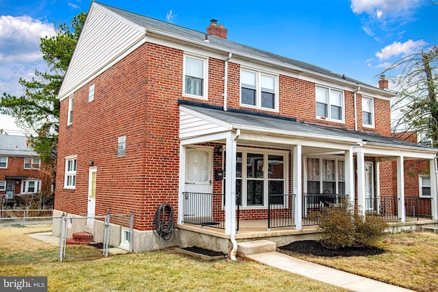 view of front of home featuring a chimney, fence, a porch, and brick siding