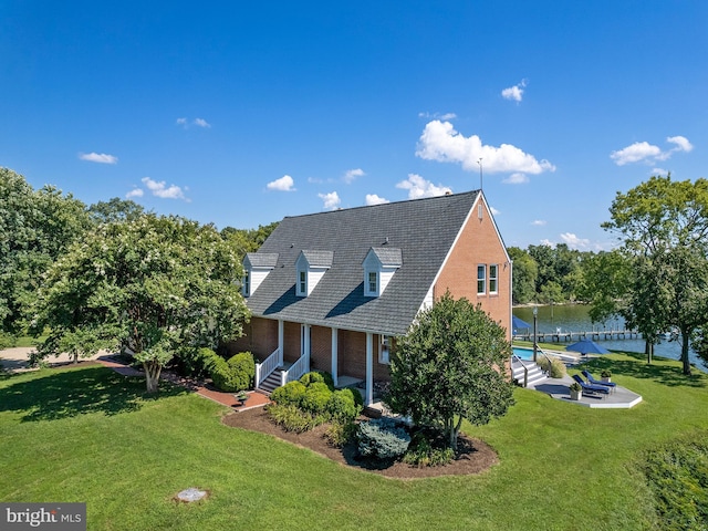 view of home's exterior featuring a yard, a water view, and brick siding