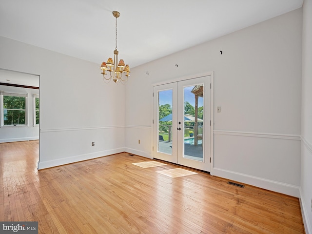 spare room featuring a wealth of natural light, french doors, visible vents, and light wood finished floors