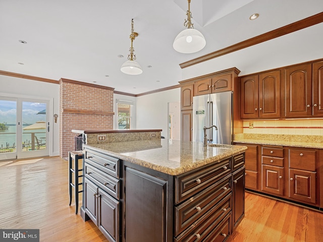 kitchen with crown molding, high quality fridge, light wood-type flooring, and a sink