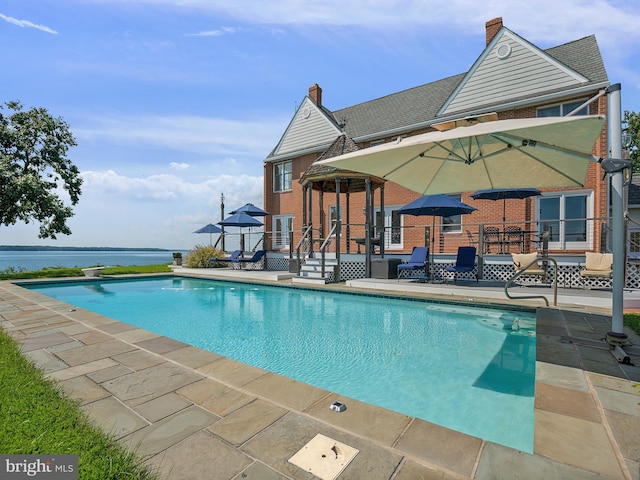 pool featuring a patio area and a deck with water view