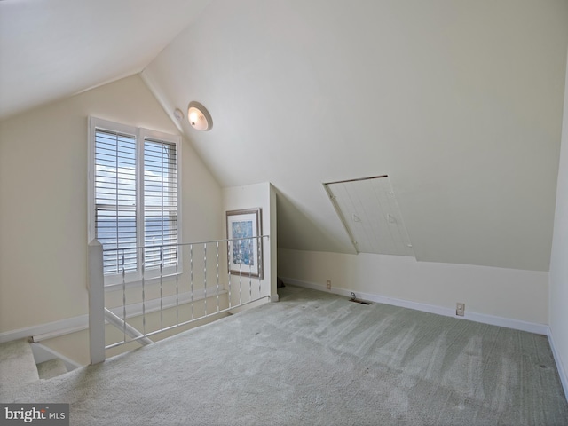 additional living space with vaulted ceiling, baseboards, and carpet floors