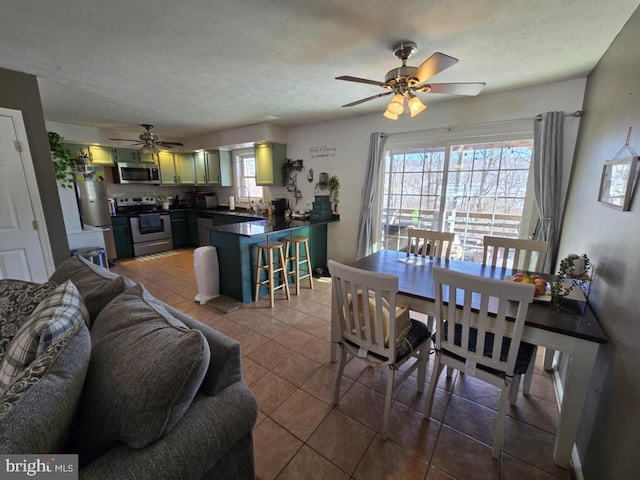 dining space featuring ceiling fan, a textured ceiling, and tile patterned floors