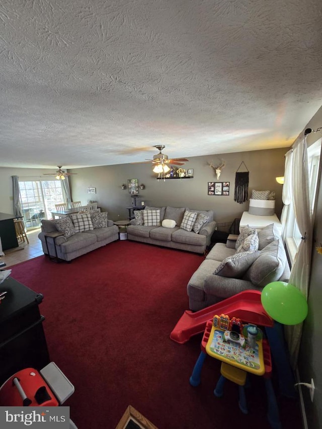 carpeted living area featuring a textured ceiling and a ceiling fan