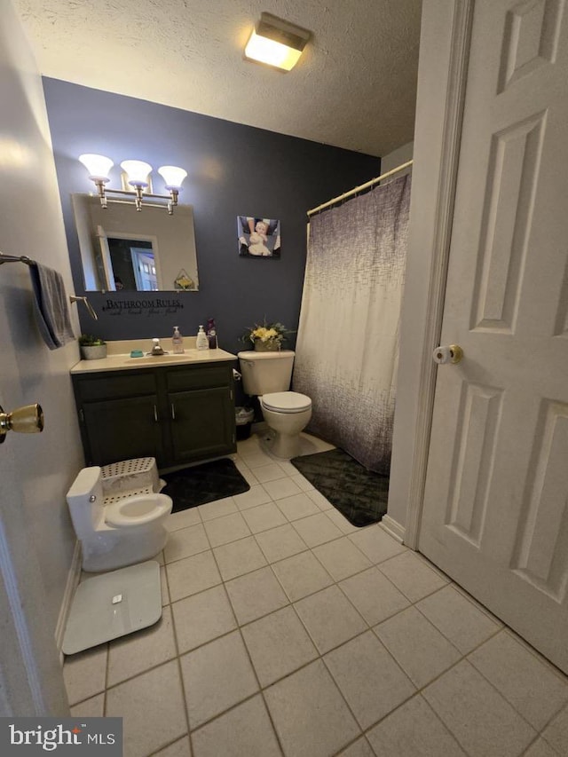 full bathroom featuring toilet, a shower with curtain, tile patterned floors, a textured ceiling, and vanity