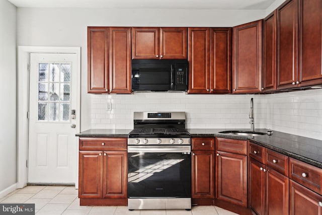 kitchen featuring reddish brown cabinets, black microwave, a sink, and stainless steel gas range oven