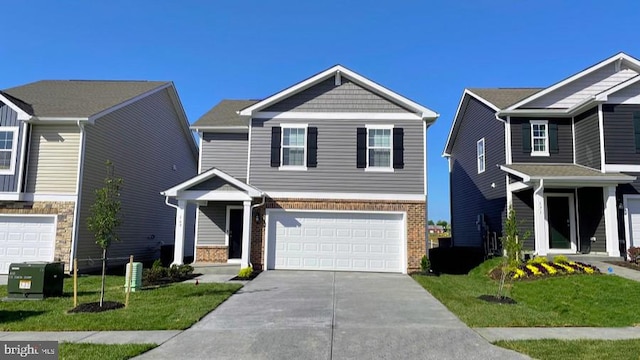 view of front of property with a garage, concrete driveway, brick siding, and a front lawn