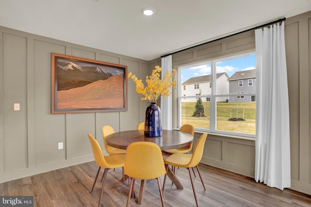 dining area featuring light wood-style floors and a decorative wall