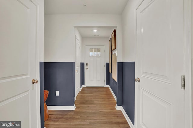 doorway to outside featuring baseboards and wood finished floors