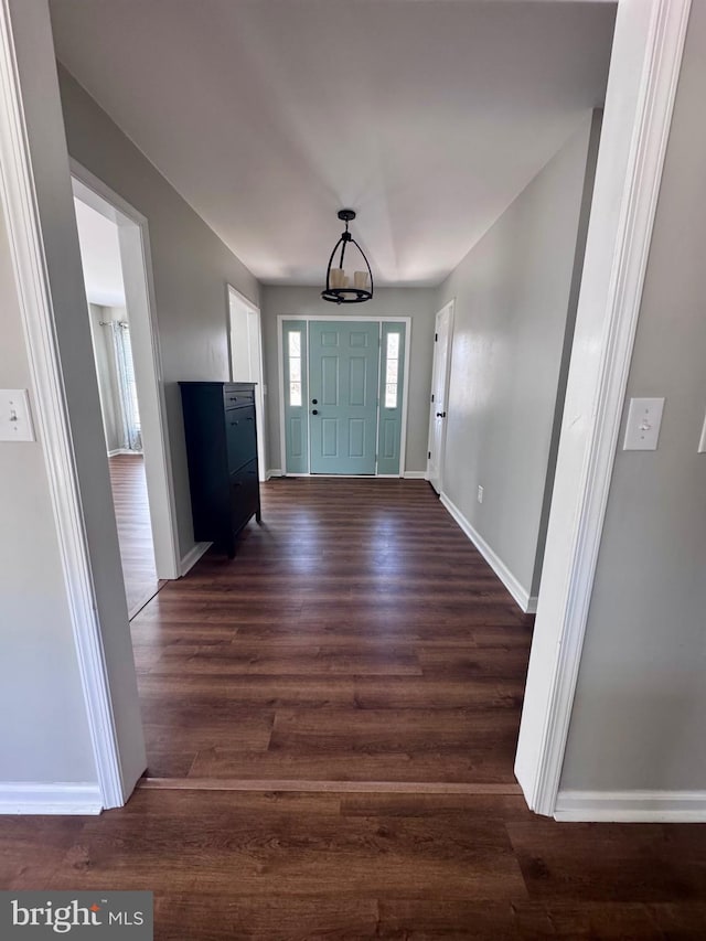 foyer featuring dark wood finished floors and baseboards