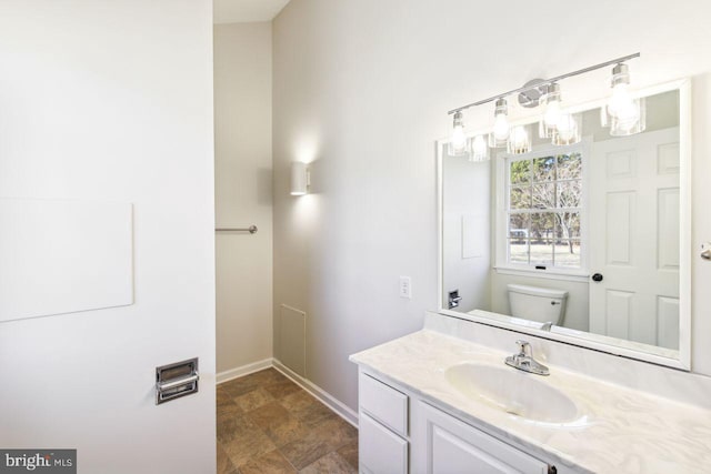 bathroom featuring vanity, toilet, and baseboards