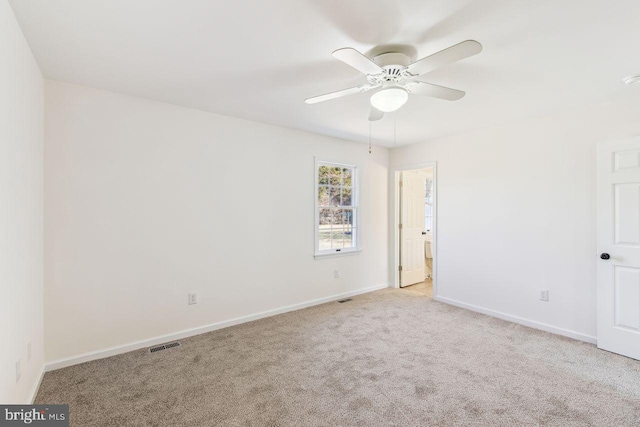 carpeted empty room with a ceiling fan, baseboards, and visible vents