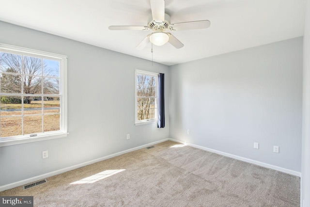 empty room featuring visible vents, ceiling fan, baseboards, and carpet