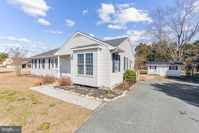 view of front of property featuring an outbuilding and gravel driveway