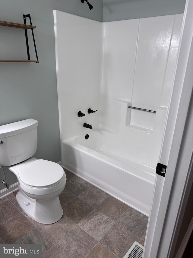 bathroom with baseboards, toilet, and shower / tub combination