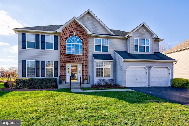 view of front facade with driveway, an attached garage, and a front yard