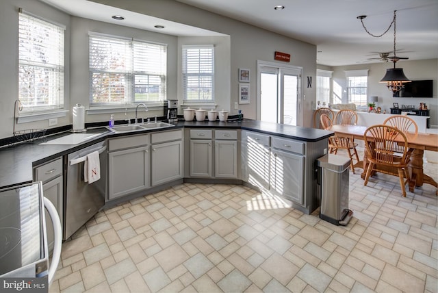 kitchen featuring a sink, dark countertops, dishwasher, and gray cabinetry