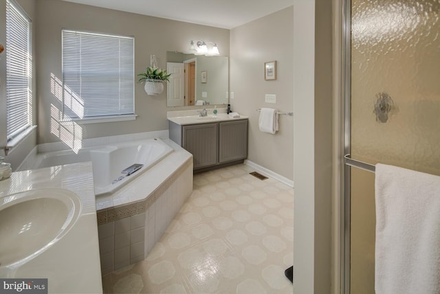 full bathroom with a garden tub, a shower with door, visible vents, vanity, and baseboards