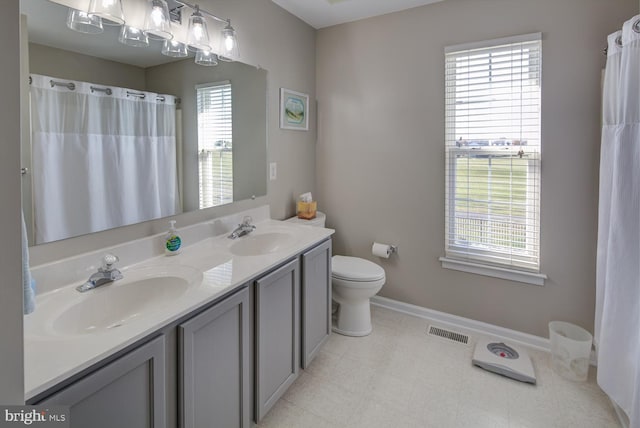 bathroom with toilet, baseboards, visible vents, and a sink