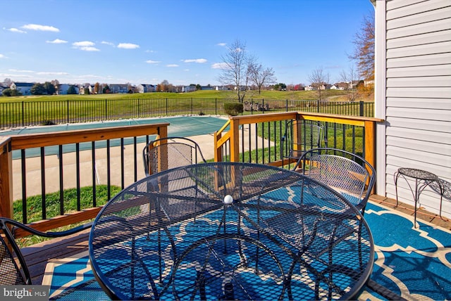 wooden deck featuring outdoor dining area, a fenced backyard, and a fenced in pool