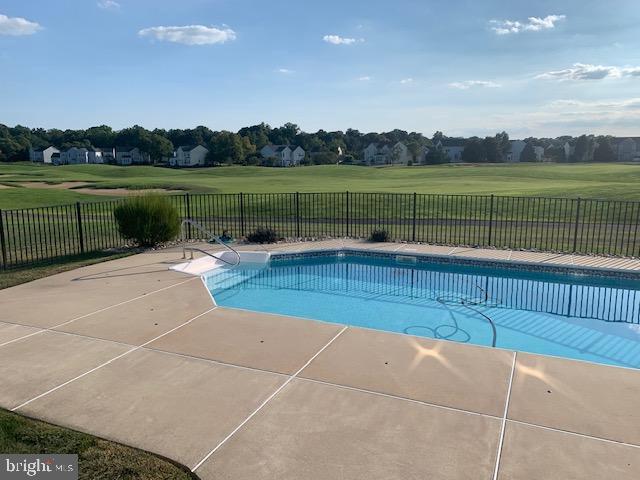 view of swimming pool featuring a fenced in pool, a fenced backyard, and a lawn