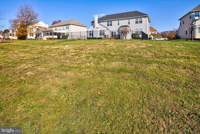 back of house with fence and a lawn