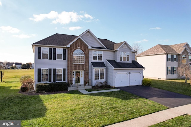 view of front of house featuring roof with shingles, brick siding, a front yard, a garage, and driveway