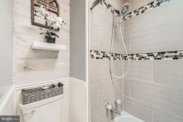 bathroom featuring  shower combination, wainscoting, and toilet