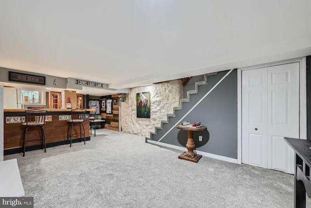 interior space with a dry bar, stairs, and baseboards