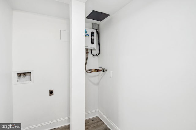 clothes washing area with tankless water heater, hookup for a washing machine, wood finished floors, baseboards, and electric dryer hookup