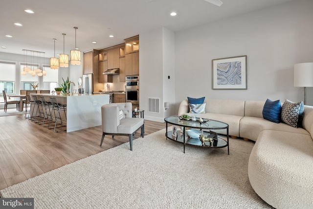 living area featuring recessed lighting, visible vents, and light wood-style floors