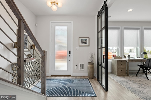 entryway with visible vents, light wood-style floors, a healthy amount of sunlight, and stairway