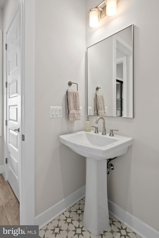 bathroom featuring tile patterned floors, baseboards, and a sink