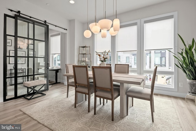 dining room featuring a barn door, recessed lighting, baseboards, and wood finished floors